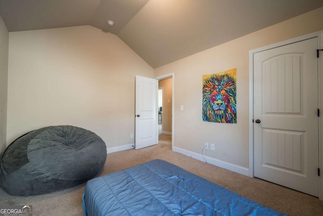 bedroom with light colored carpet and lofted ceiling