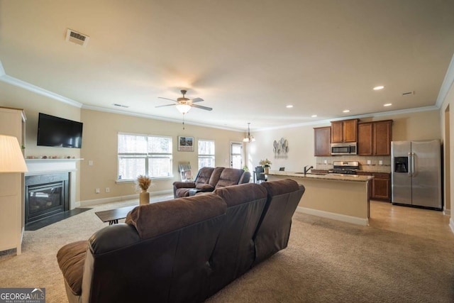 living room featuring ceiling fan, sink, and ornamental molding