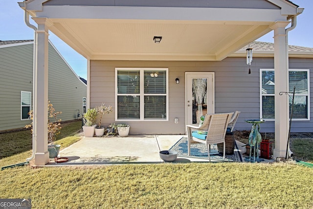 rear view of property featuring a lawn and a patio area