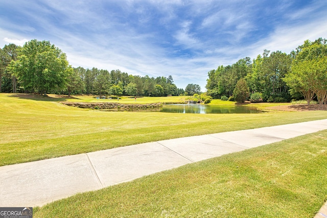 view of property's community with a yard and a water view