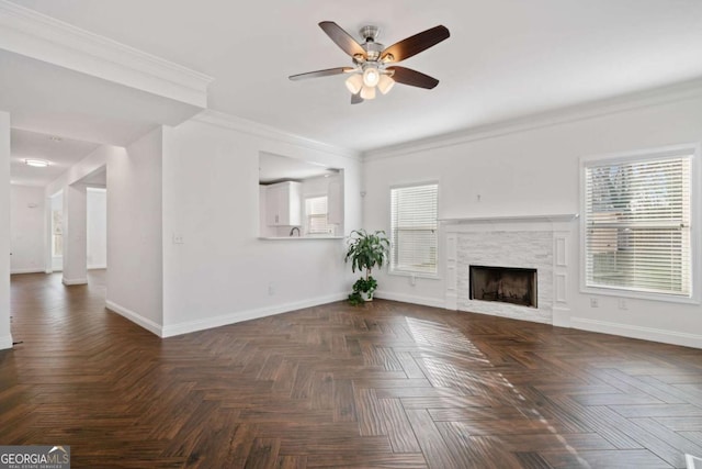 unfurnished living room with dark parquet flooring, a fireplace, ceiling fan, and ornamental molding