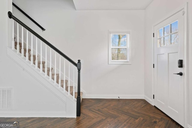 entryway featuring dark parquet flooring