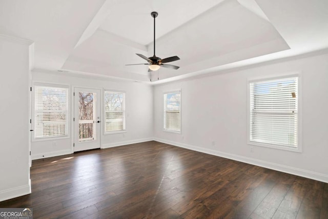 spare room featuring ceiling fan, dark hardwood / wood-style floors, and a tray ceiling