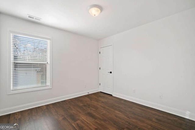 empty room with dark hardwood / wood-style flooring