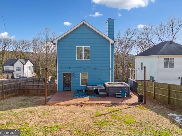 back of house with a hot tub, a deck, a yard, and a patio area