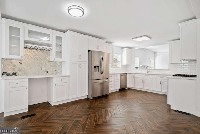 kitchen featuring sink, stainless steel appliances, white cabinetry, and dark parquet floors