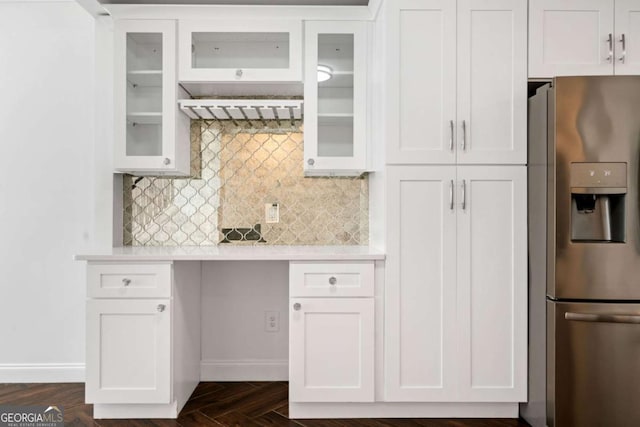 kitchen featuring white cabinets, stainless steel fridge, and backsplash