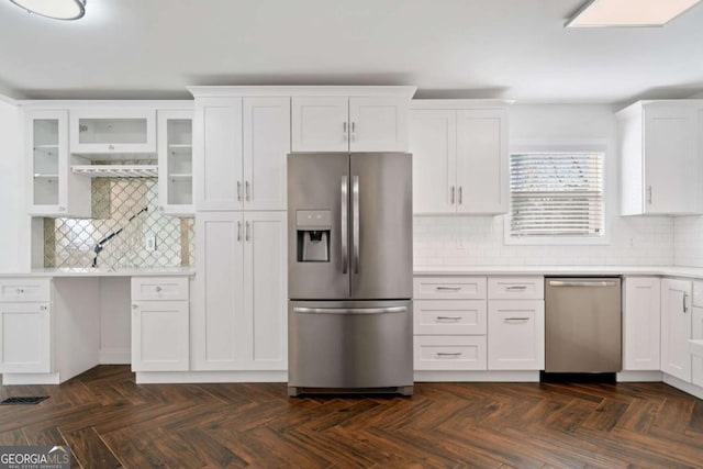 kitchen featuring appliances with stainless steel finishes, white cabinets, backsplash, and dark parquet flooring