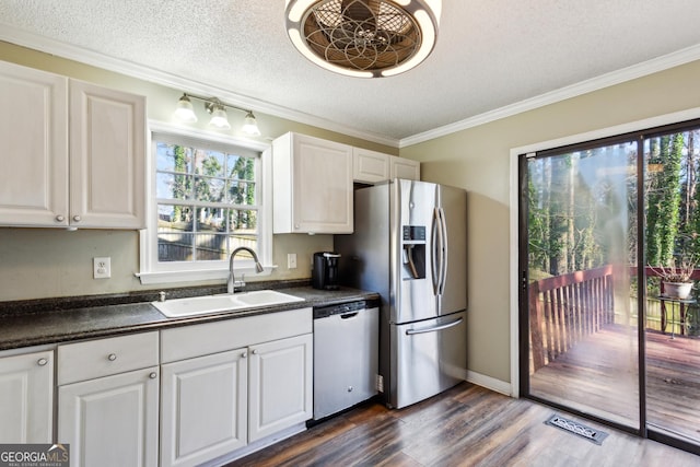 kitchen featuring appliances with stainless steel finishes, a textured ceiling, dark hardwood / wood-style floors, white cabinets, and sink