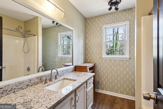 bathroom with vanity, a textured ceiling, hardwood / wood-style flooring, and plenty of natural light