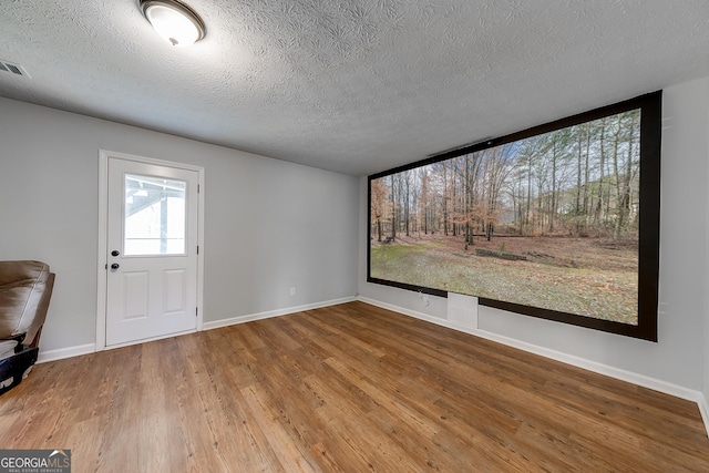 interior space with wood-type flooring and a textured ceiling