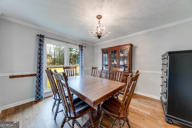 dining room with wood-type flooring, ornamental molding, and a chandelier