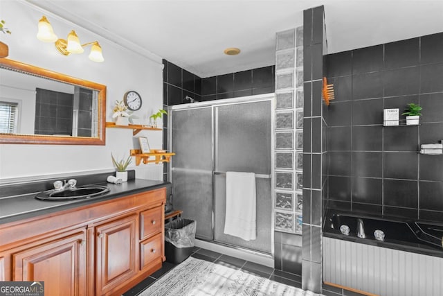 bathroom with tiled shower, tile patterned flooring, and vanity