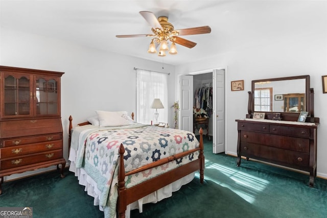 carpeted bedroom with a walk in closet, a closet, and ceiling fan