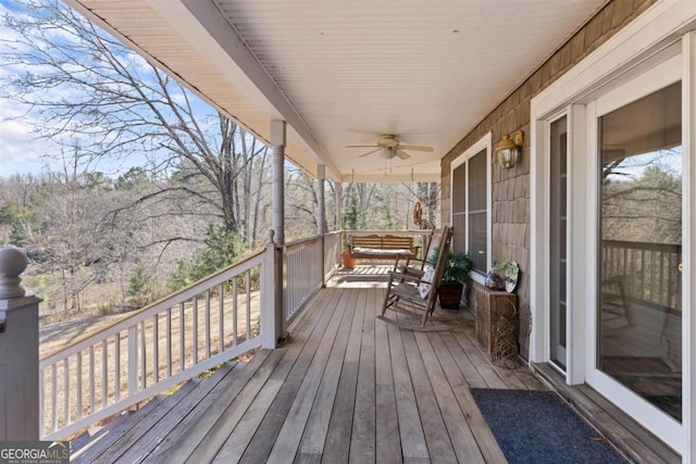 wooden terrace featuring ceiling fan and a porch