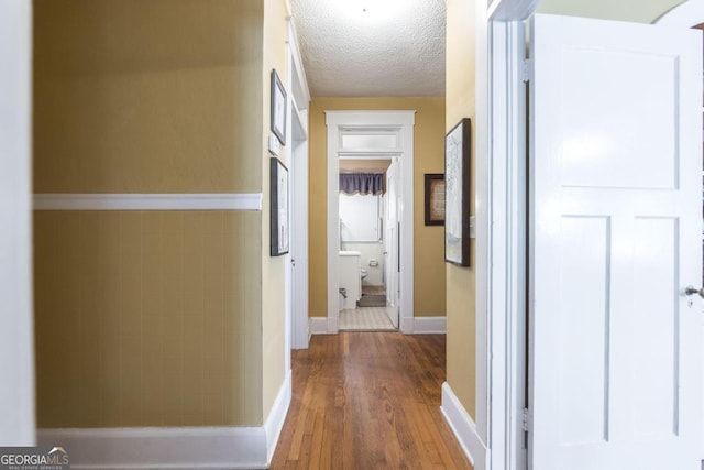 corridor featuring hardwood / wood-style flooring and a textured ceiling