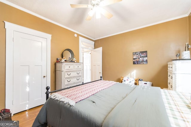 bedroom featuring ornamental molding, light wood-type flooring, and ceiling fan