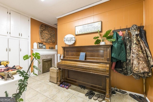 misc room with crown molding, wood walls, and light tile patterned floors