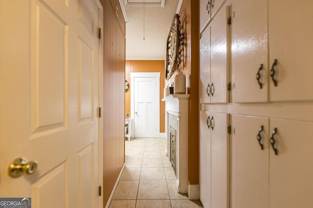 corridor featuring light tile patterned flooring and ornamental molding