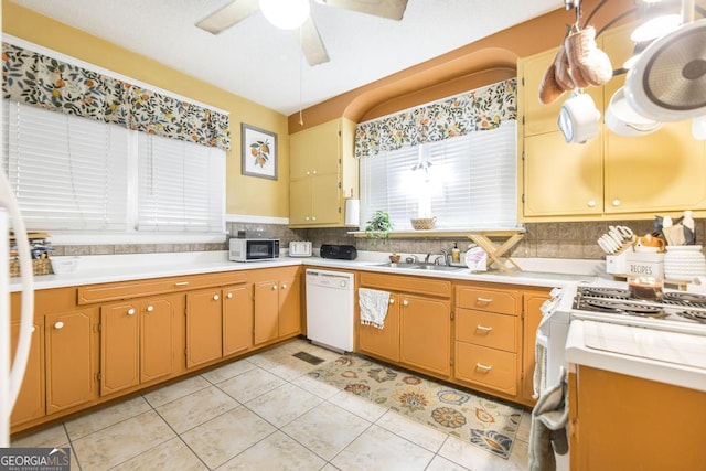 kitchen featuring dishwasher, hanging light fixtures, light tile patterned flooring, ceiling fan, and sink