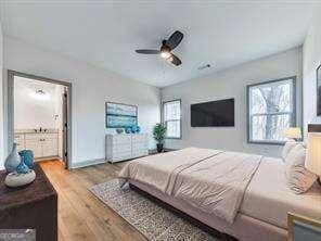 bedroom featuring ensuite bath, ceiling fan, and light hardwood / wood-style flooring