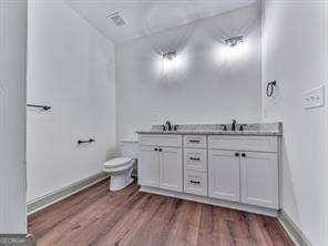 bathroom featuring hardwood / wood-style floors, vanity, and toilet