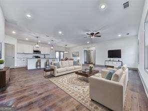 living room with dark hardwood / wood-style flooring and ceiling fan