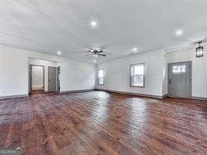 unfurnished living room with ceiling fan and dark hardwood / wood-style floors