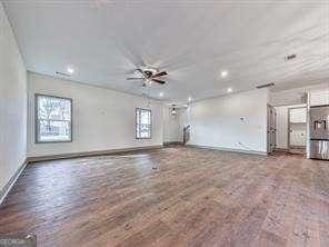 unfurnished living room featuring ceiling fan and wood-type flooring