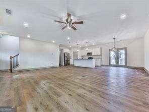 unfurnished living room featuring ceiling fan and dark hardwood / wood-style flooring