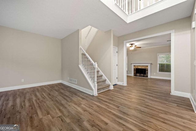 unfurnished living room featuring ceiling fan and hardwood / wood-style flooring