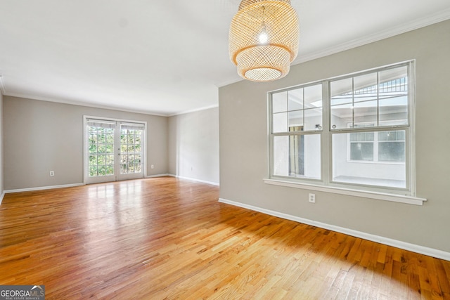 empty room with crown molding and light hardwood / wood-style flooring