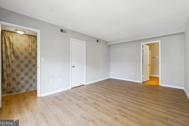 unfurnished room with light wood-type flooring