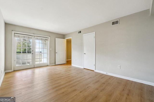 empty room featuring light wood-type flooring and french doors