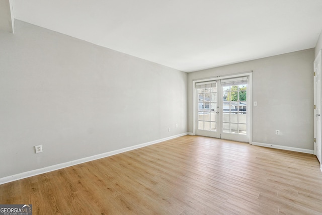 spare room with light hardwood / wood-style flooring and french doors