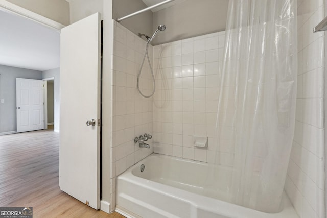 bathroom with hardwood / wood-style floors and shower / bathtub combination with curtain