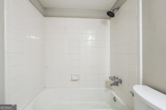 bathroom with toilet and tiled shower / bath combo