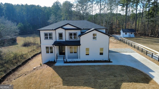 view of front property featuring a porch and a storage shed