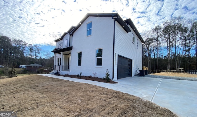 view of home's exterior with a balcony, a garage, and central AC