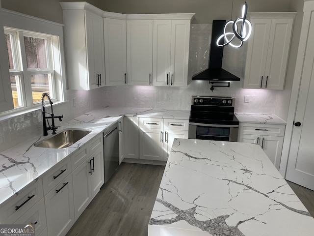 kitchen with stainless steel appliances, light stone countertops, pendant lighting, sink, and wall chimney range hood