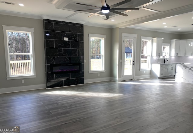 unfurnished living room featuring sink, hardwood / wood-style flooring, ceiling fan, and plenty of natural light