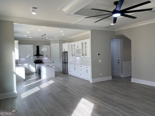 kitchen with stainless steel appliances, white cabinetry, wall chimney exhaust hood, tasteful backsplash, and a kitchen island