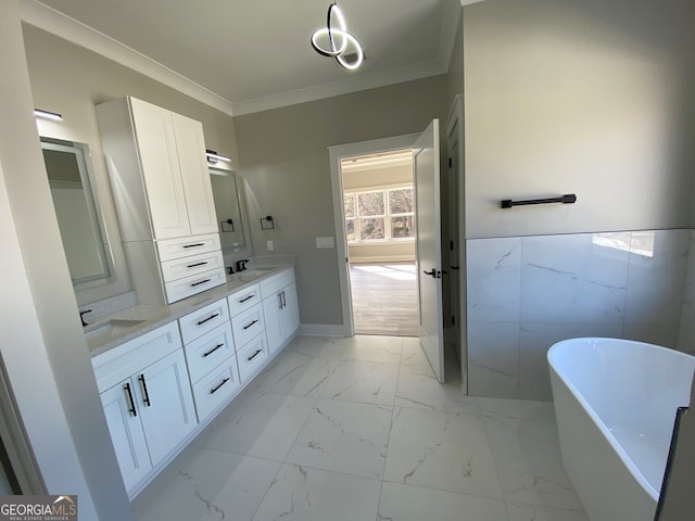 bathroom with vanity, tile walls, crown molding, and a tub