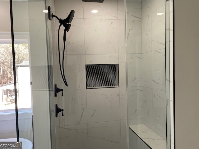 bathroom featuring a tile shower and a wealth of natural light