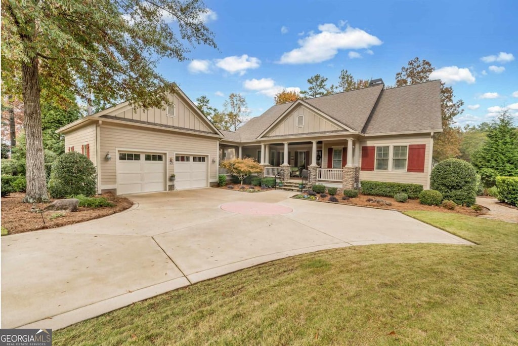 craftsman-style home with a front yard, a garage, and covered porch