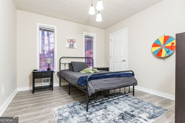 bedroom featuring a textured ceiling and hardwood / wood-style flooring