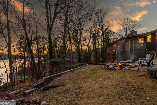 yard at dusk featuring a fire pit and a patio