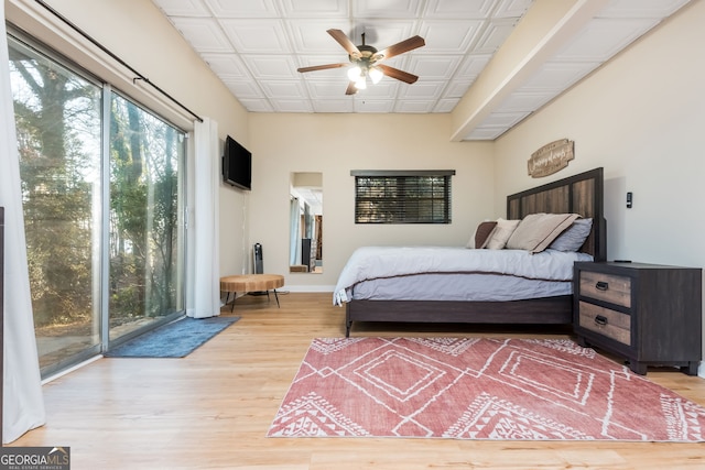 bedroom featuring ceiling fan, access to exterior, and hardwood / wood-style floors