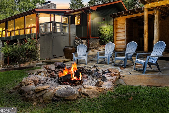 patio terrace at dusk featuring a sunroom