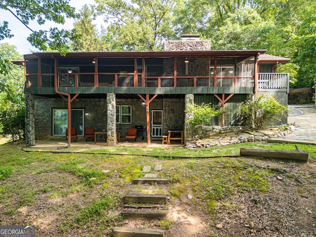 rear view of house featuring a patio area and a sunroom